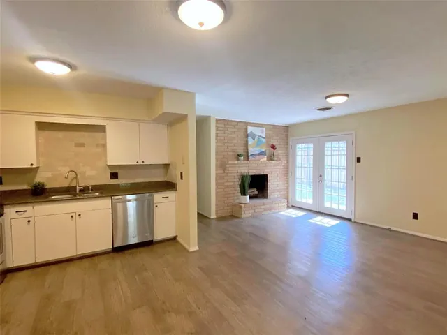 a large kitchen with granite countertop a stove top oven a sink a counter space and cabinets