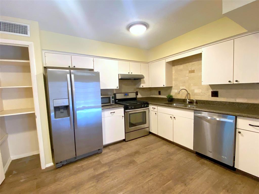 7406 Walling Lane Dallas, TX 75231 - Photo 6 of 15 a kitchen with granite countertop a refrigerator and a sink