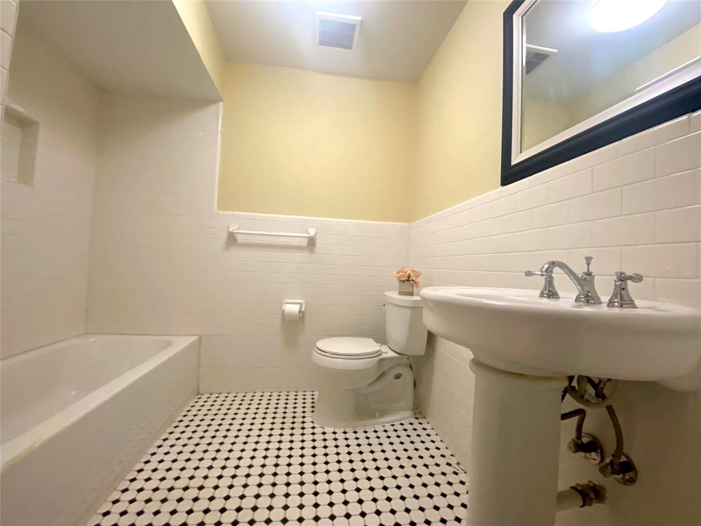7406 Walling Lane Dallas, TX 75231 - Photo 10 of 15 a bathroom with a sink a toilet and a bathtub