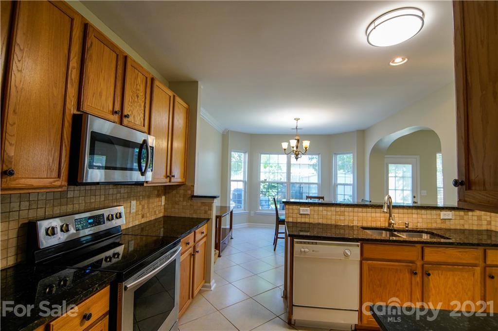 2318 Mirage Place Fort Mill, SC 29708 - Photo 12 of 27 a kitchen with stainless steel appliances granite countertop a stove a sink and a microwave