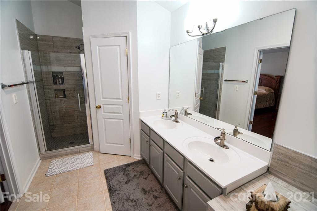 2318 Mirage Place Fort Mill, SC 29708 - Photo 18 of 27 a bathroom with a sink a mirror and a shower
