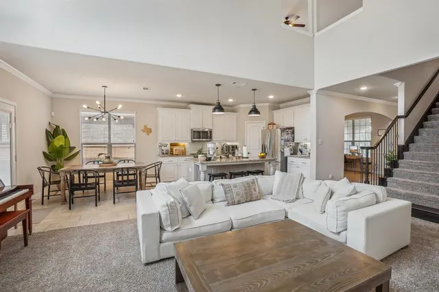 a living room with fireplace furniture and a kitchen view