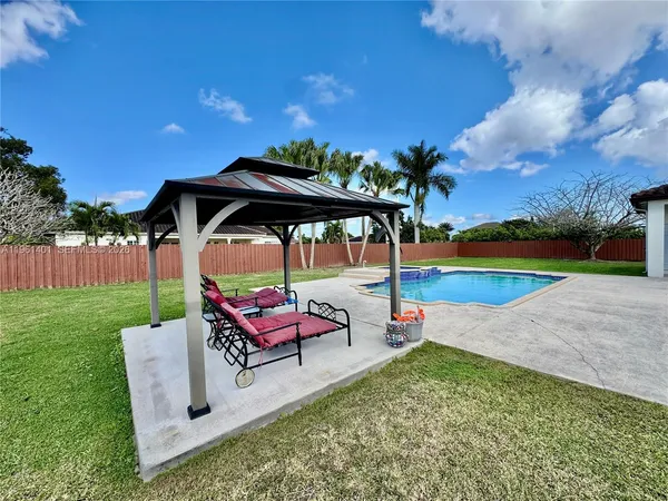an outdoor sitting area with couch and umbrella