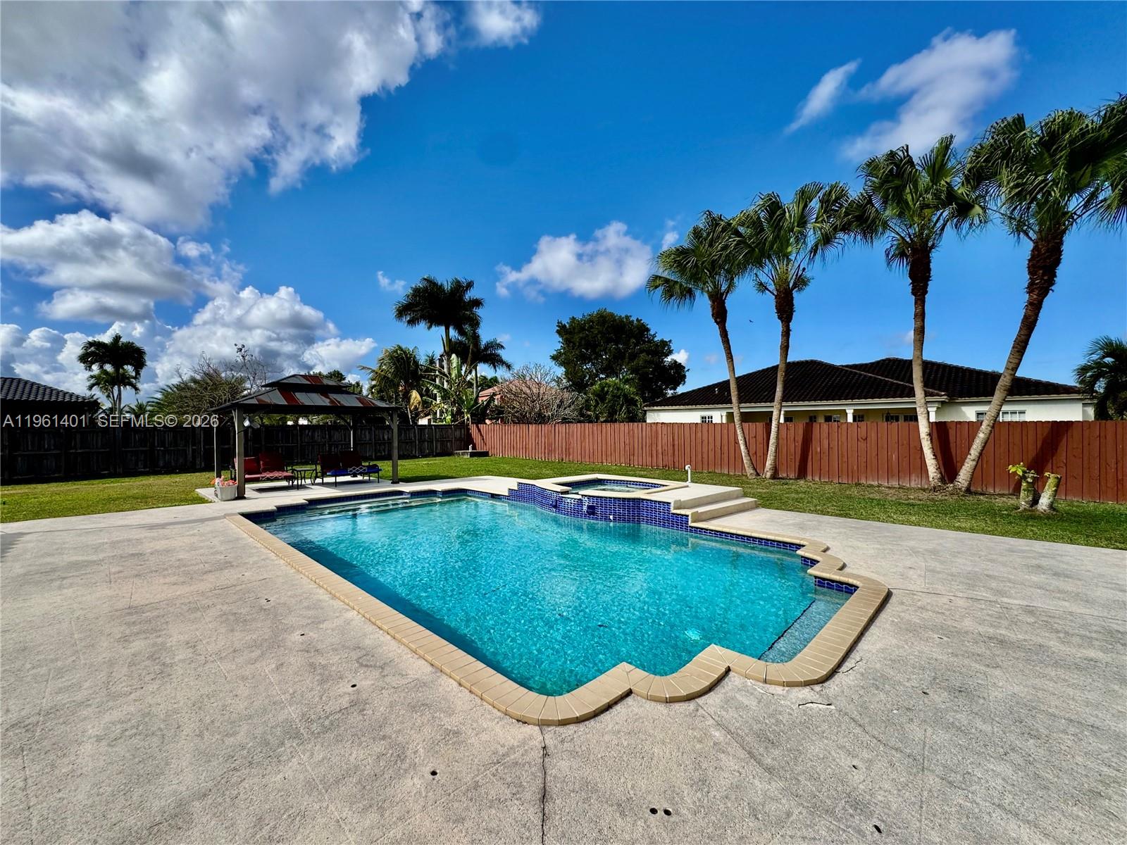 20449 Southwest 328th Street Homestead, FL 33030 - Photo 17 of 34 a view of a swimming pool with a chair and tables