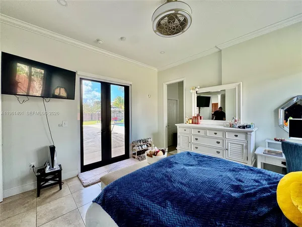 a bed room with a bed mirror and a flat screen tv