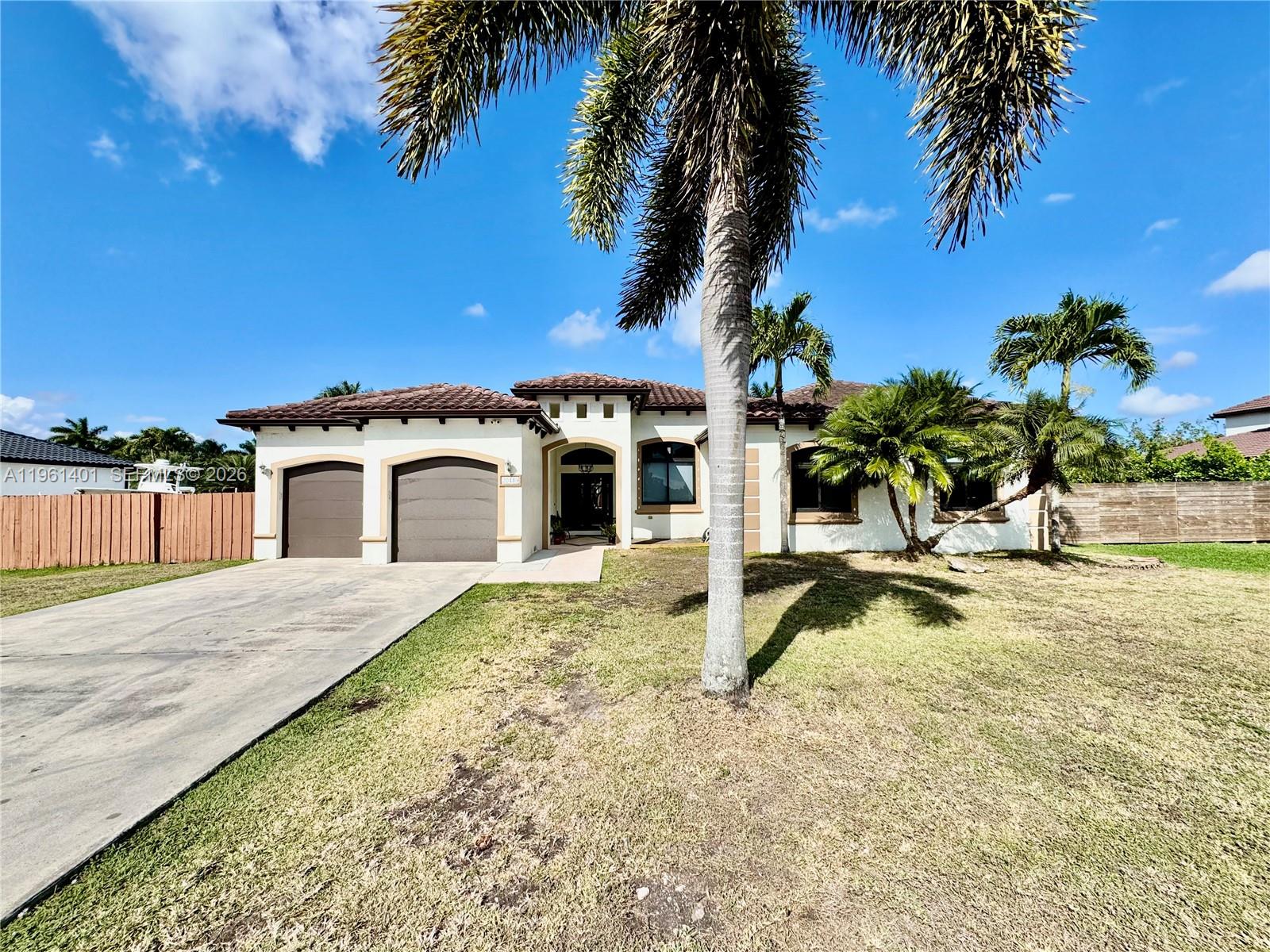 20449 Southwest 328th Street Homestead, FL 33030 - Photo 2 of 34 a house with palm tree in front of it