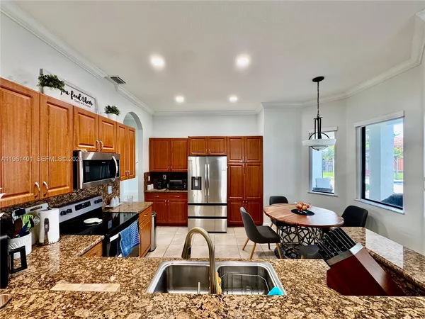 a kitchen with stainless steel appliances granite countertop a sink stove and refrigerator