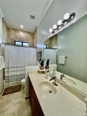 a bathroom with a sink a large mirror and a shower