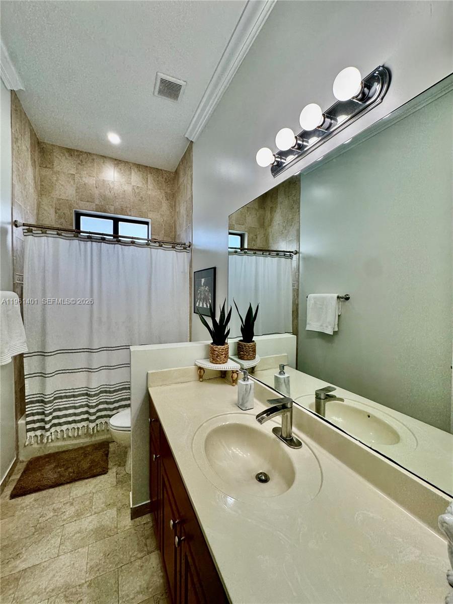 20449 Southwest 328th Street Homestead, FL 33030 - Photo 26 of 34 a bathroom with a sink a large mirror and a shower