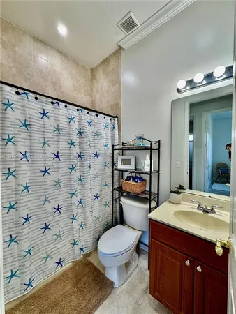 a bathroom with a sink toilet vanity and shower