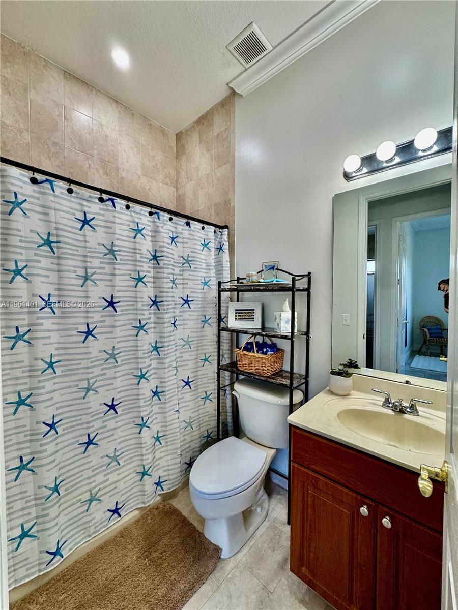 20449 Southwest 328th Street Homestead, FL 33030 - Photo 29 of 34 a bathroom with a sink toilet vanity and shower