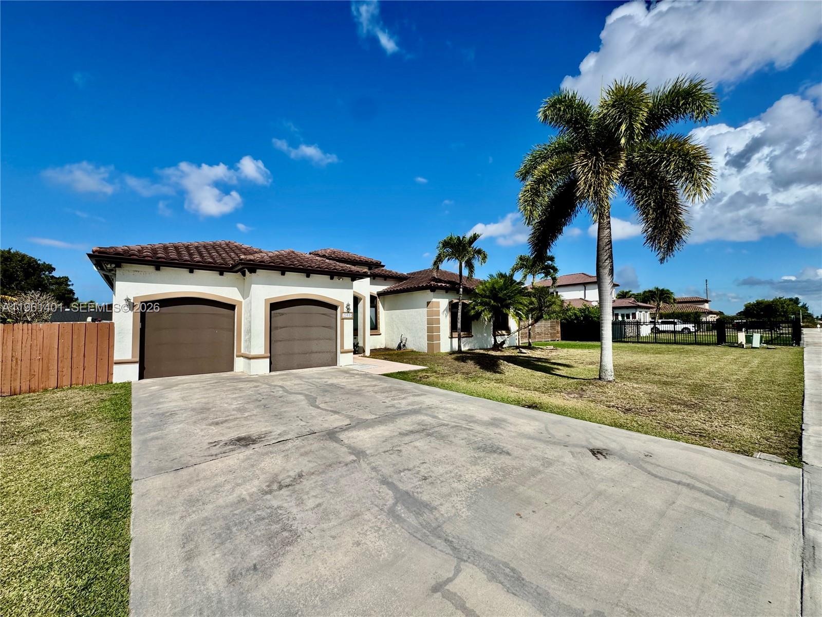 20449 Southwest 328th Street Homestead, FL 33030 - Photo 3 of 34 a house with a yard and a garage