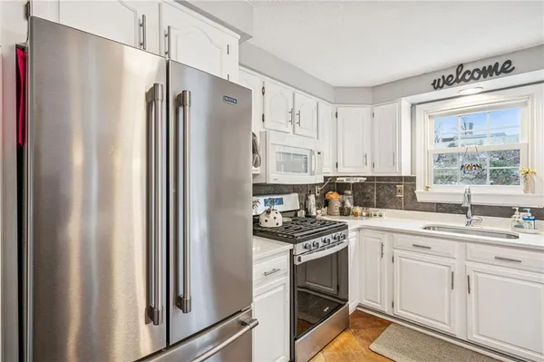 a kitchen with stainless steel appliances a refrigerator sink and stove