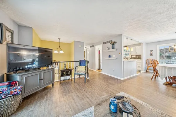 a living room with stainless steel appliances furniture and a kitchen view