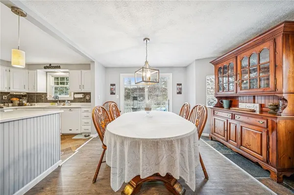 a dining room with furniture a chandelier and wooden floor