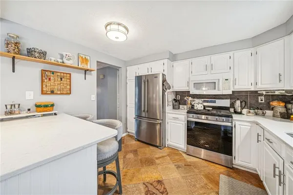 a kitchen with a stove a refrigerator and a sink