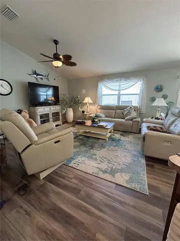 a living room with furniture flat screen tv and window