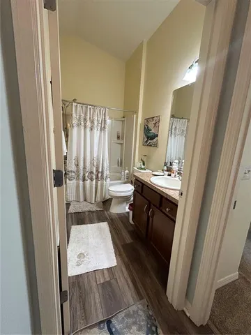a bathroom with a sink a toilet a mirror and shower