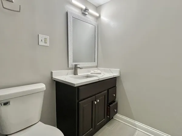 a bathroom with a sink toilet and mirror