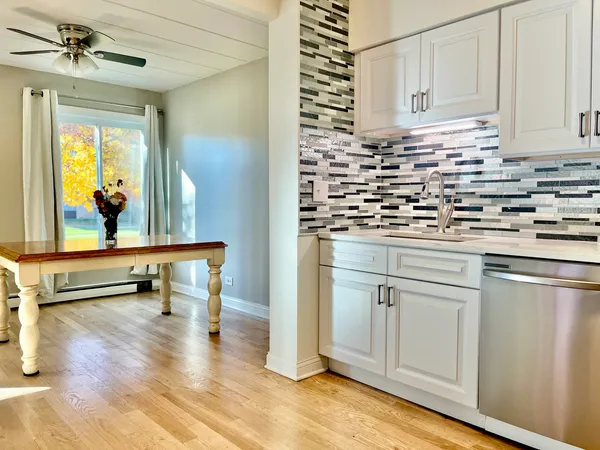a kitchen with appliances cabinets and wooden floor