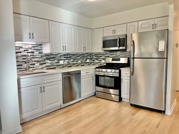 a kitchen with white cabinets and stainless steel appliances