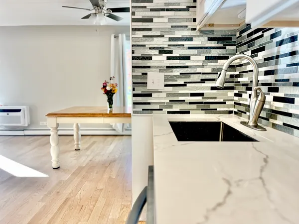 a kitchen with a sink a stove and chairs
