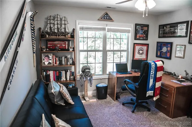 a view of a workspace with furniture bookshelf and a window