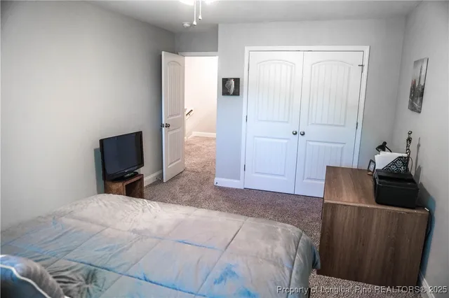 a bedroom with bed and a flat tv screen on the dresser