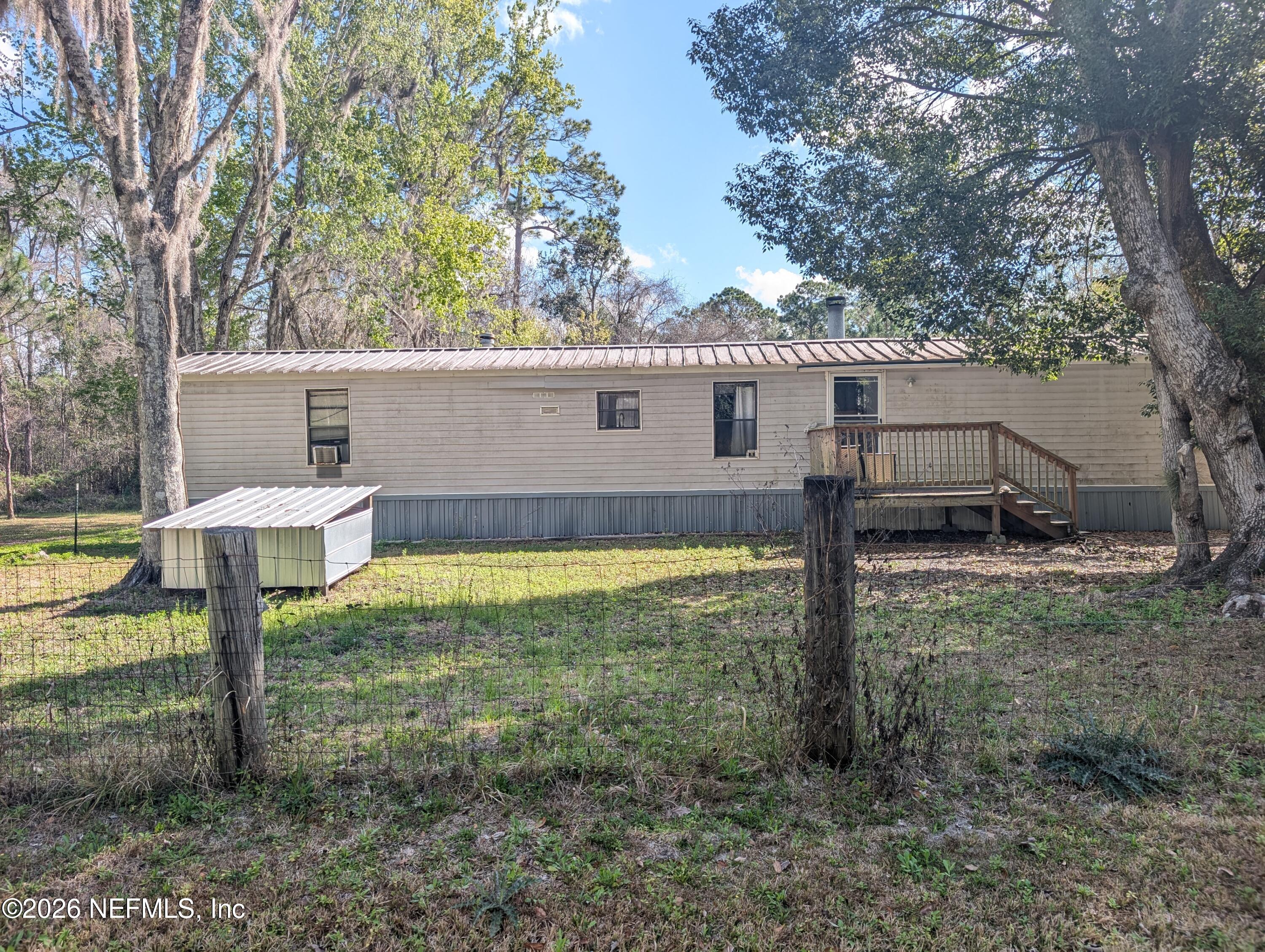 a view of a house with backyard and a tree