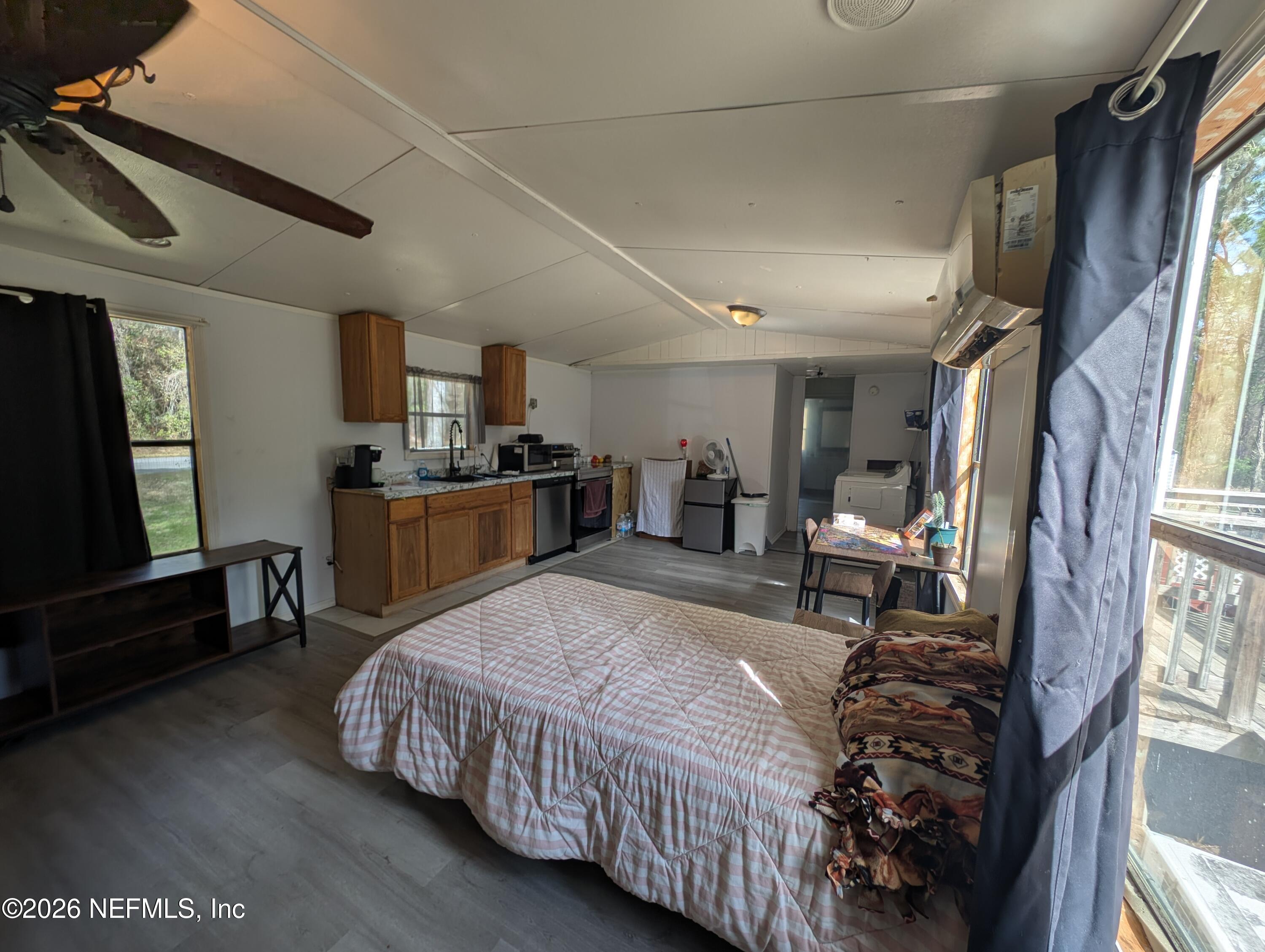114 Durden Road Interlachen, FL 32148 - Photo 4 of 30 a bed room with a bed window and a chair