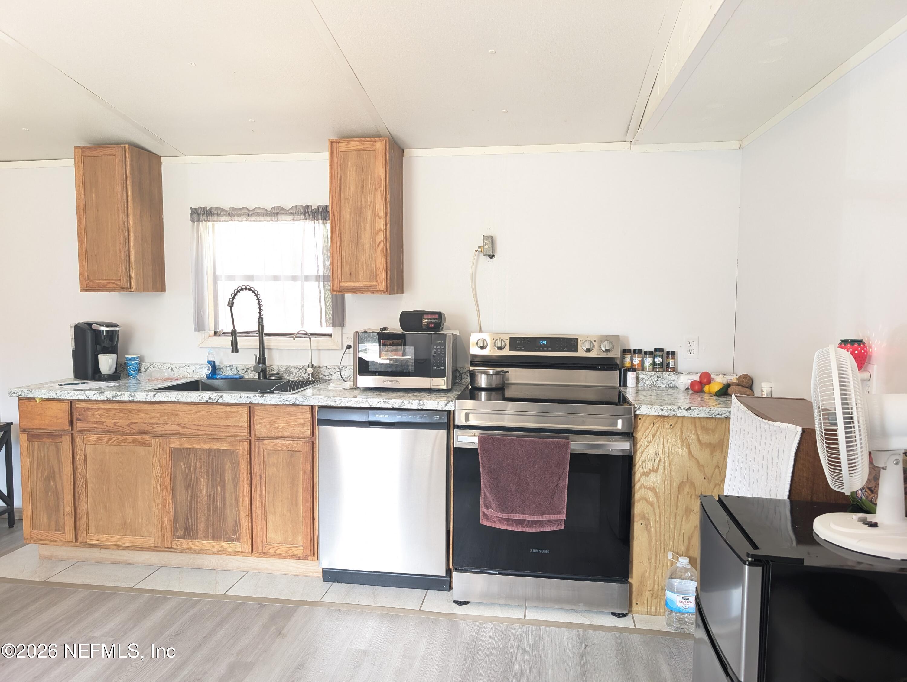 114 Durden Road Interlachen, FL 32148 - Photo 5 of 30 a kitchen with stainless steel appliances granite countertop a stove and a sink