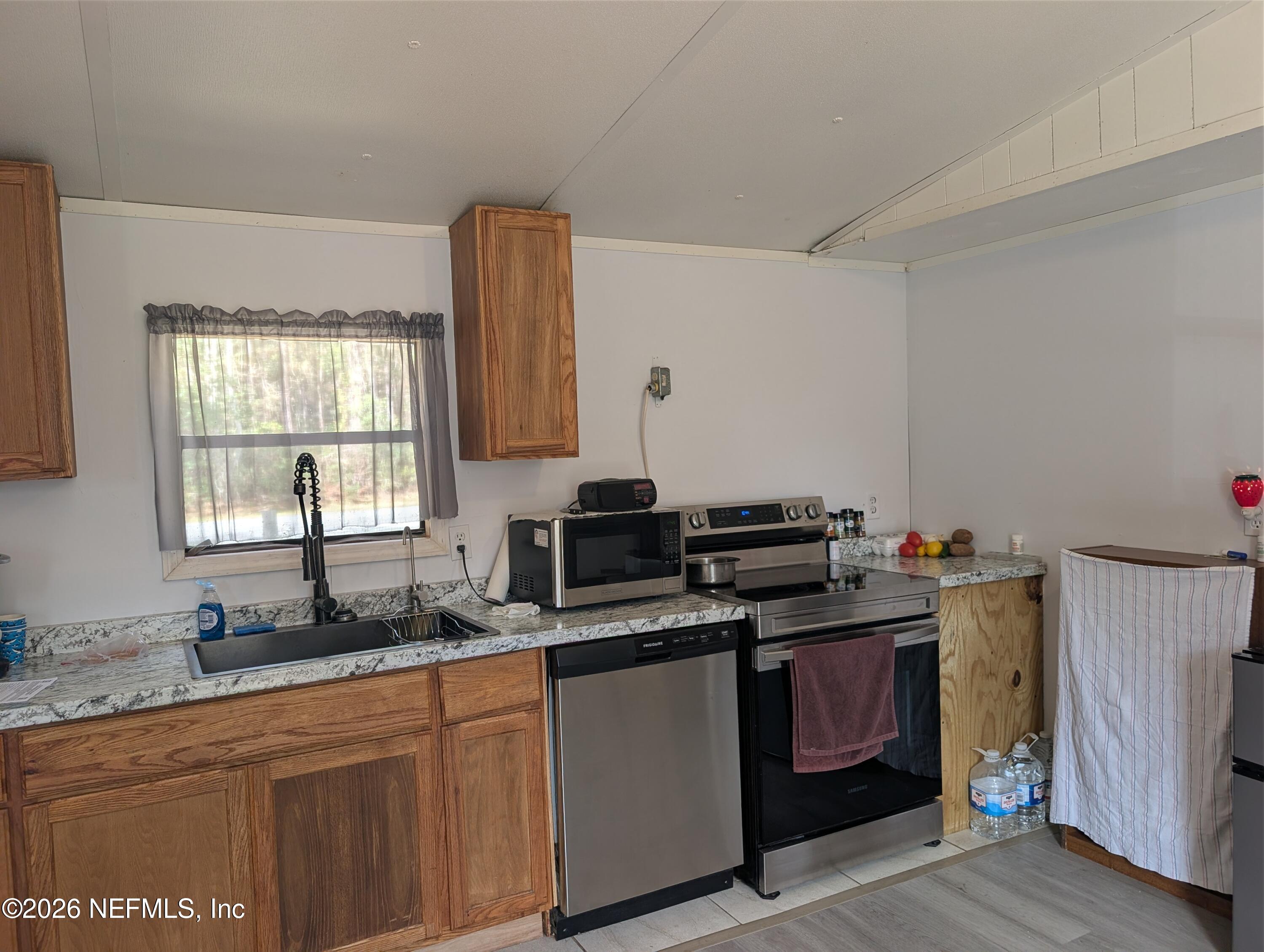 114 Durden Road Interlachen, FL 32148 - Photo 6 of 30 a kitchen with stainless steel appliances a sink stove and cabinets