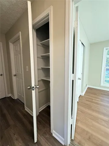a view of a hallway with wooden floor and staircase