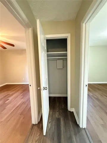 a view of a hallway with wooden floor and closet