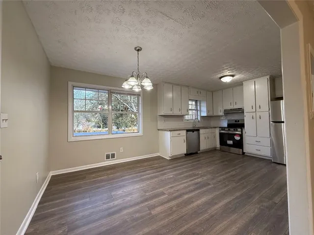 a view of a kitchen with stove and cabinets