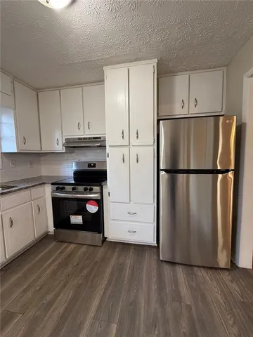 a kitchen with a refrigerator and a stove top oven