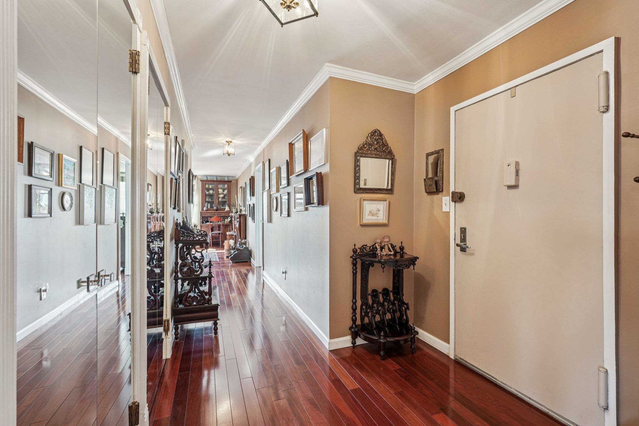 6040 Boulevard East, Unit 23G West New York, NJ 07093 - Photo 13 of 32 a view of a hallway with wooden floor and stairs