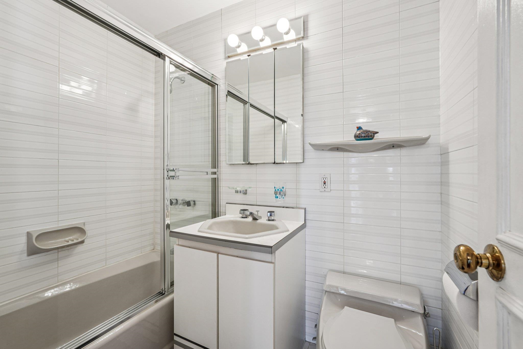 6040 Boulevard East, Unit 23G West New York, NJ 07093 - Photo 23 of 32 a bathroom with a sink a toilet and shower