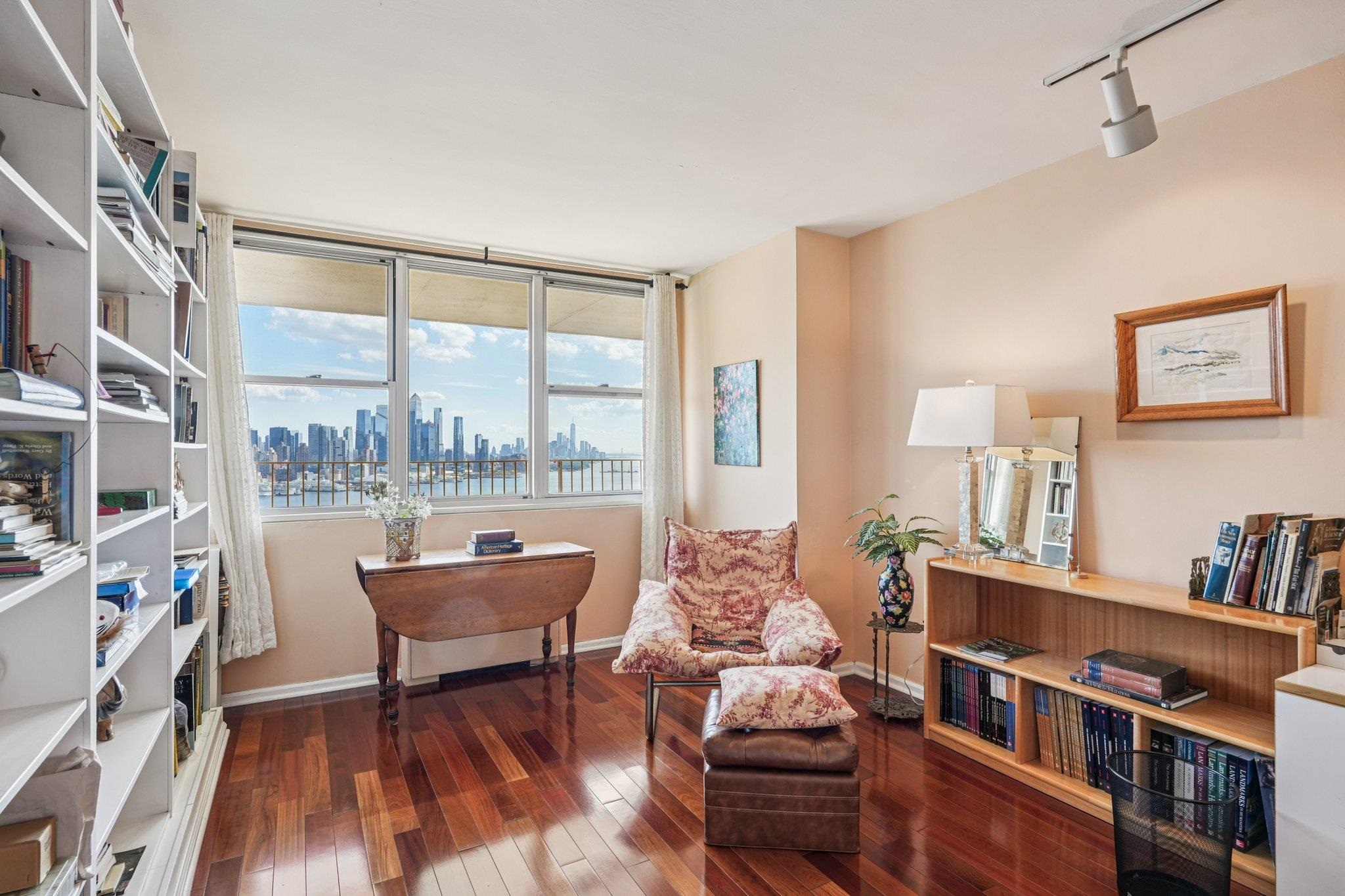 6040 Boulevard East, Unit 23G West New York, NJ 07093 - Photo 24 of 32 a living room with furniture and a floor to ceiling window