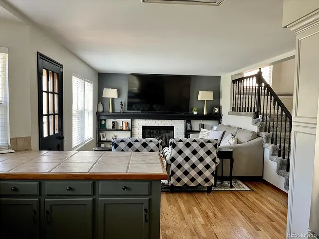 a living room with furniture a flat screen tv and a fireplace