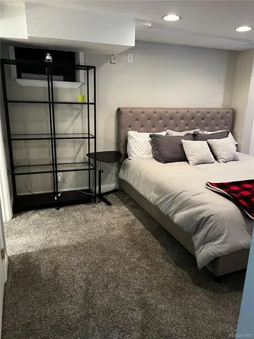 a spacious bedroom with a bed and wooden floor