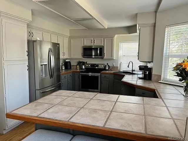 a kitchen with stainless steel appliances a refrigerator sink stove and microwave
