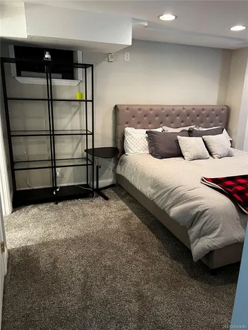 a spacious bedroom with a bed and wooden floor