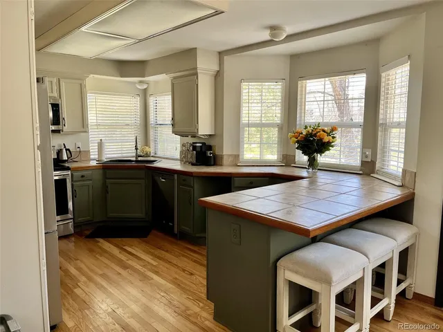 a kitchen with a table chairs sink and wooden floor