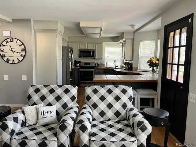 a kitchen with stainless steel appliances and wooden floor