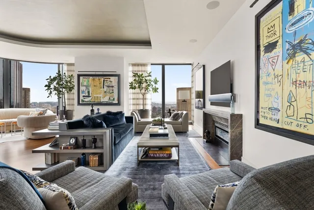 a living room with furniture fireplace and a large window