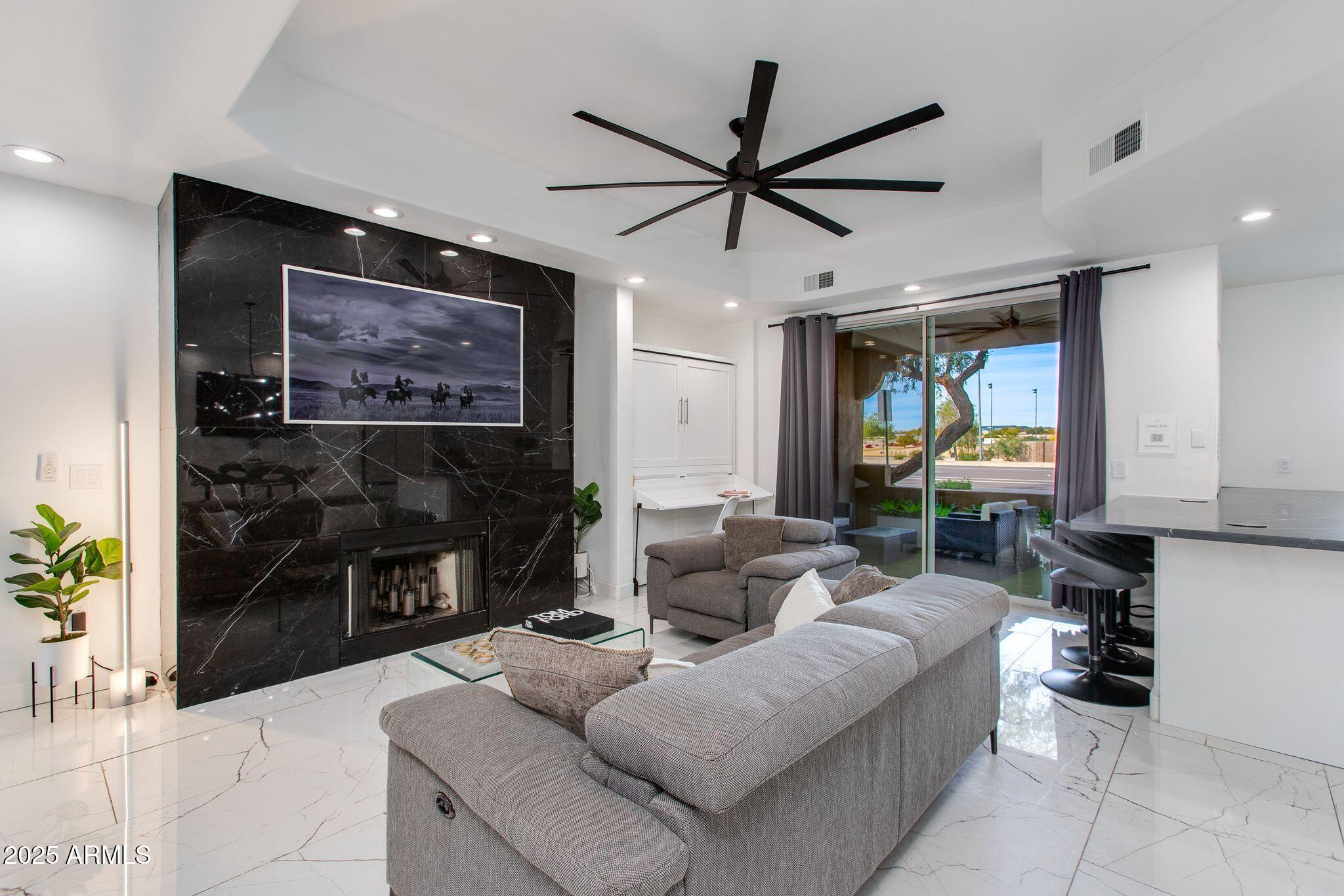 8245 East Bell Road, Unit 150 Scottsdale, AZ 85260 - Photo 2 of 12 a living room with furniture and a fireplace