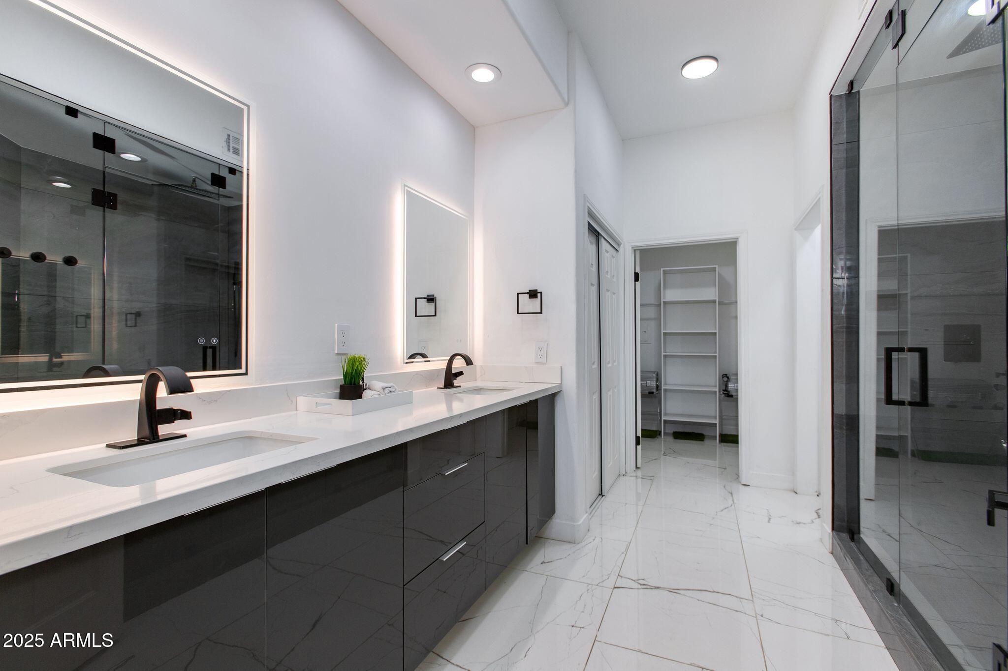 8245 East Bell Road, Unit 150 Scottsdale, AZ 85260 - Photo 6 of 12 a bathroom with a double vanity sink mirror and shower