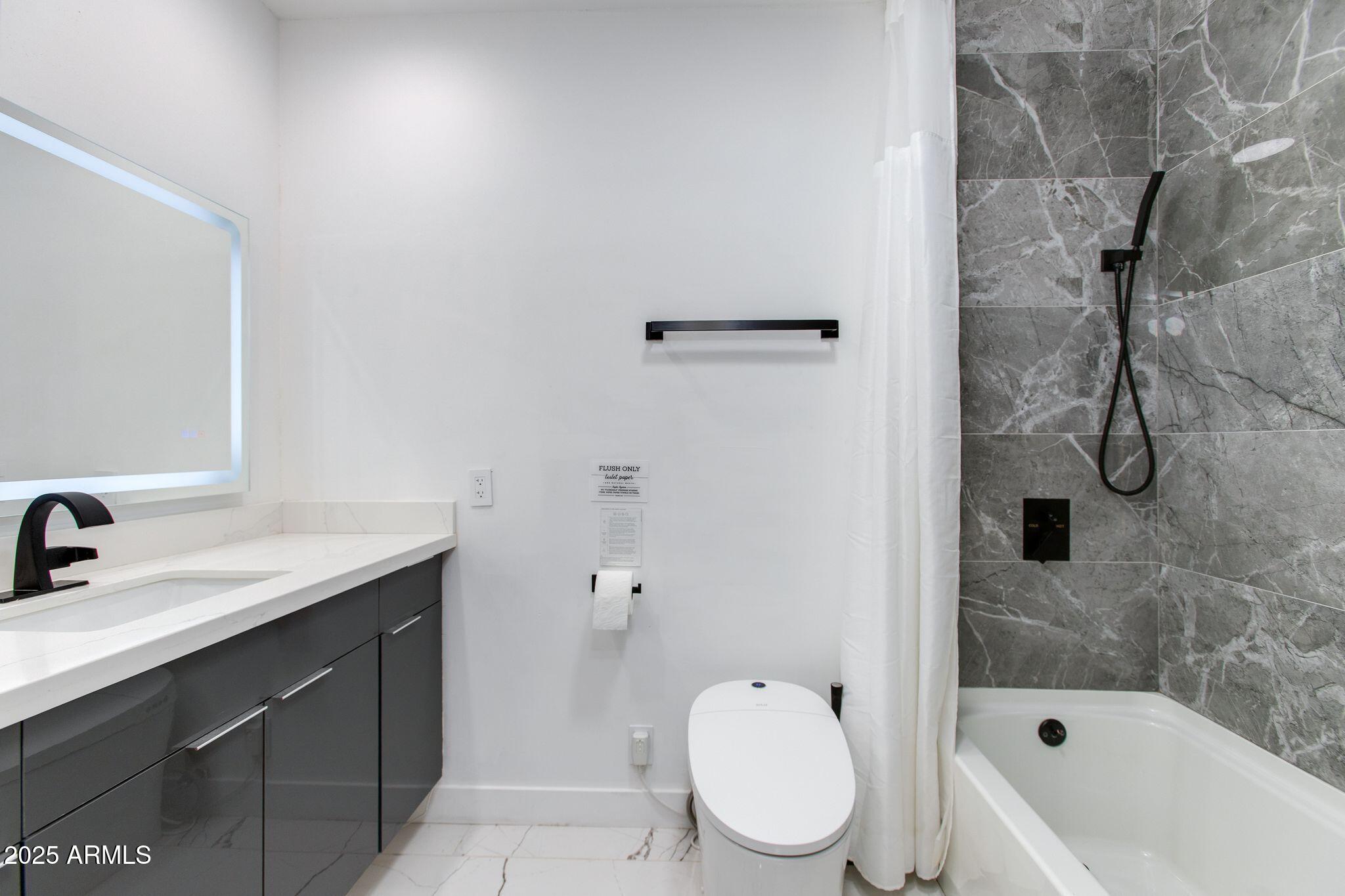8245 East Bell Road, Unit 150 Scottsdale, AZ 85260 - Photo 9 of 12 a bathroom with a sink toilet vanity and shower