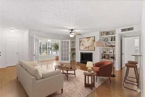 a living room with furniture a fireplace and a large window